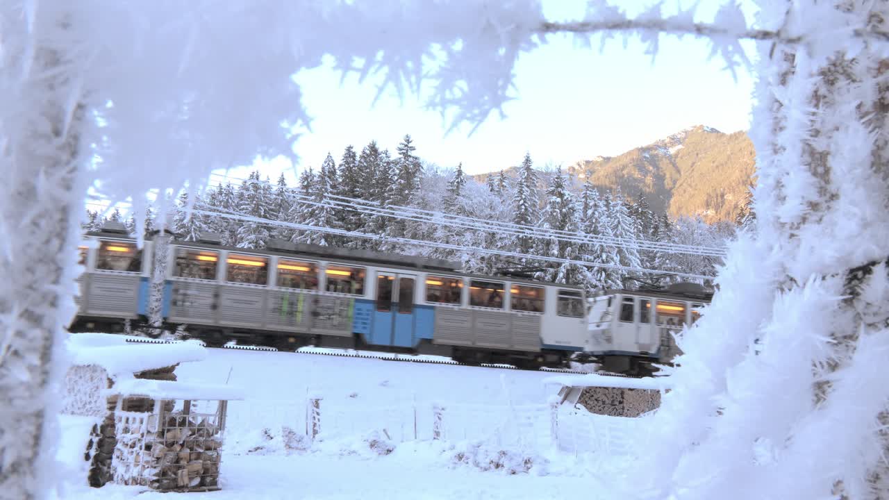 Narrow gauge train with a rack and pinion system climbing a mountain with a steep slope in a winter scenery