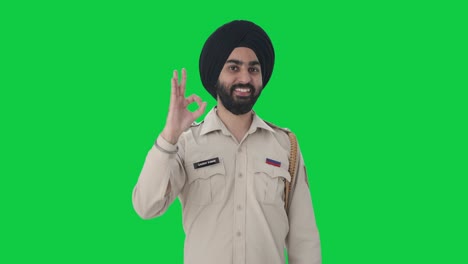 happy sikh indian police man showing okay sign green screen