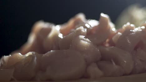 close up shot of raw uncooked chicken fillets that have been cut for a curry