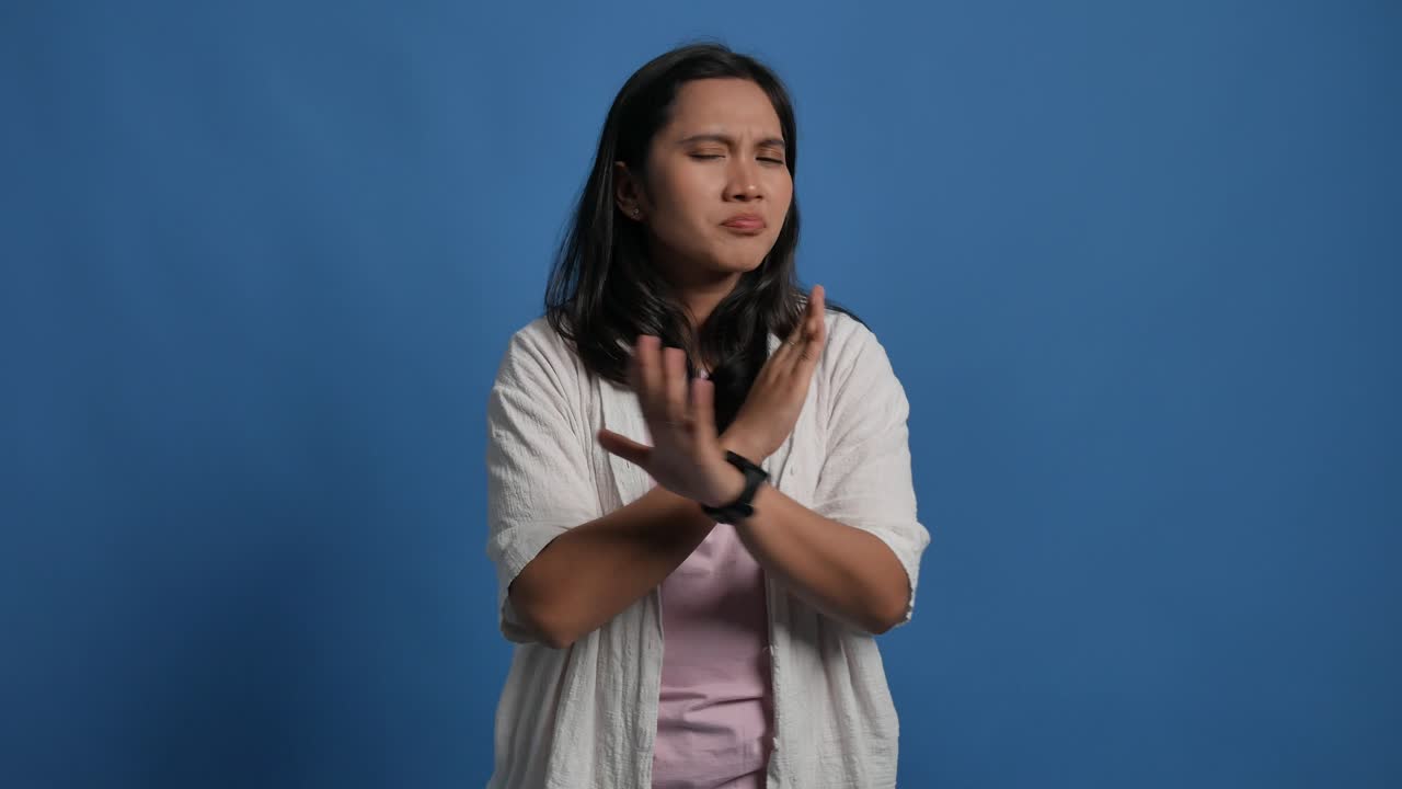 Displeased young asian woman 20s years old isolated on blue background in studio. People lifestyle concept. Pointing fingers on herself ask say who me no thanks i do not need it
