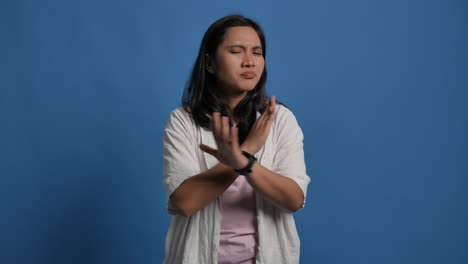 displeased young asian woman 20s years old isolated on blue background in studio. people lifestyle concept. pointing fingers on herself ask say who me no thanks i do not need it