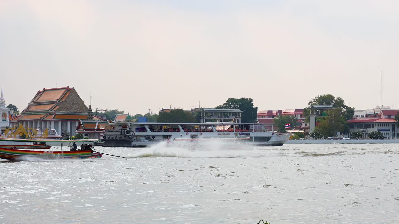 A longtail boat speeds across the Chao Phraya River in Bangkok, Thailand, against a backdrop of traditional architecture and urban scenery