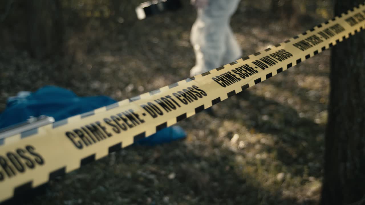 Crime scene photographer and yellow tape do not cross, outside shot