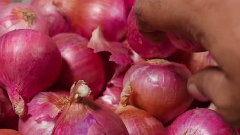 person picking red onions from basket. internal shot, close up shot, stable shot, 4k.