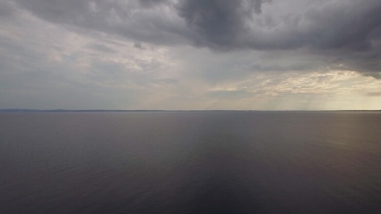 Aerial view of quiet sea grey clouds in evening sky