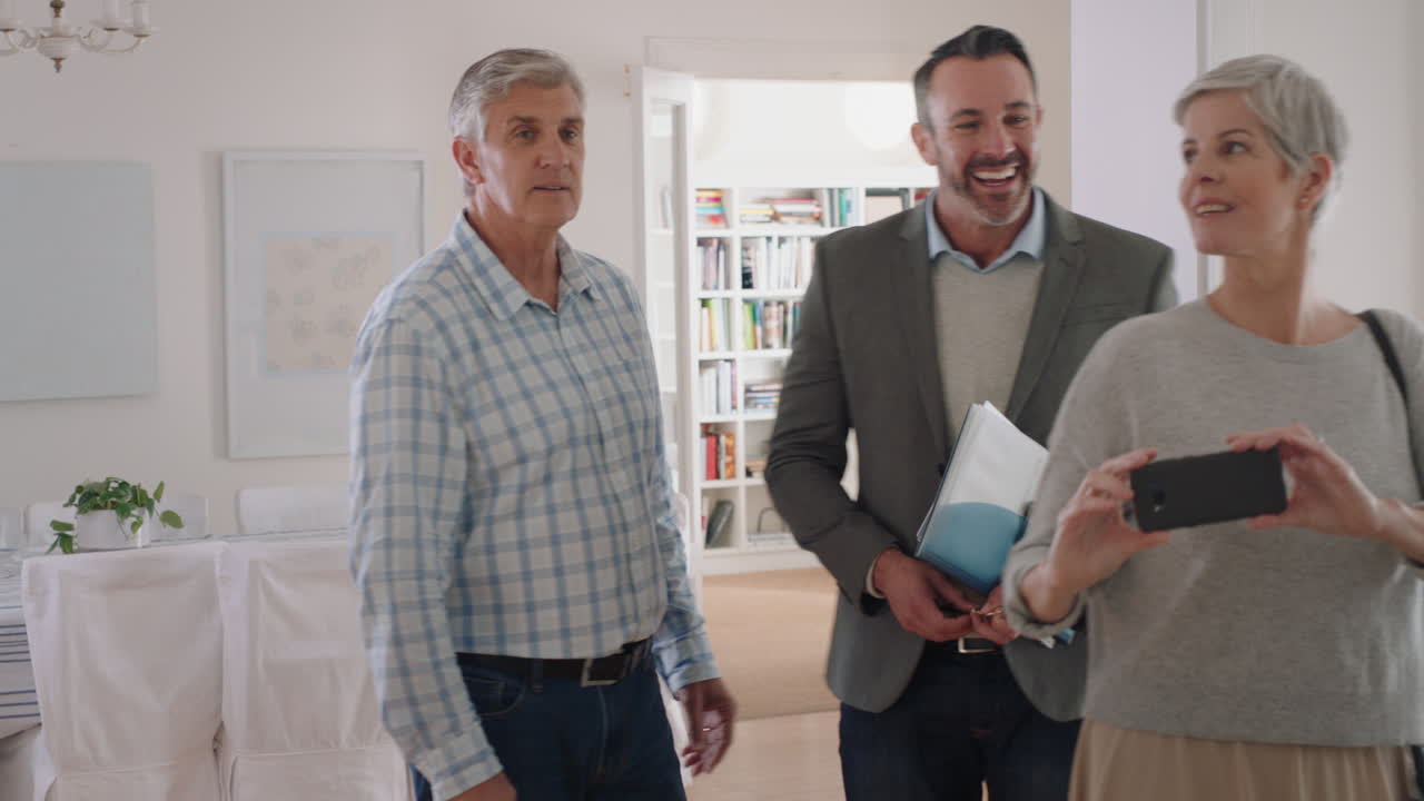 부동산 에이전트 는 성숙 한 부부 를 보여 주는 새로운 집 을 소개 하는 부동산 투자 행복 한 고객 들 이 부동산 에이전트 와 손을 흔들고 성공적 으로 집 을 구입 하는 4k 영상