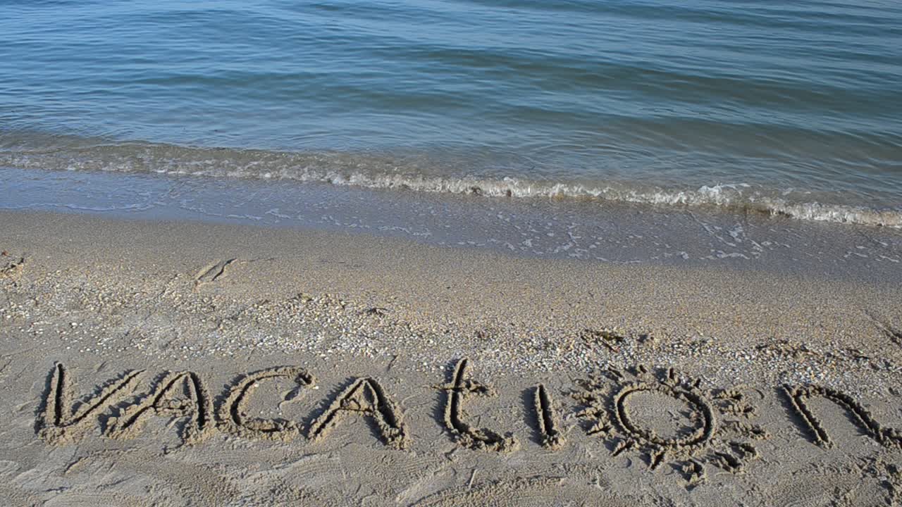La scritta "Vacanza" sulla sabbia. Scritta sulla sabbia