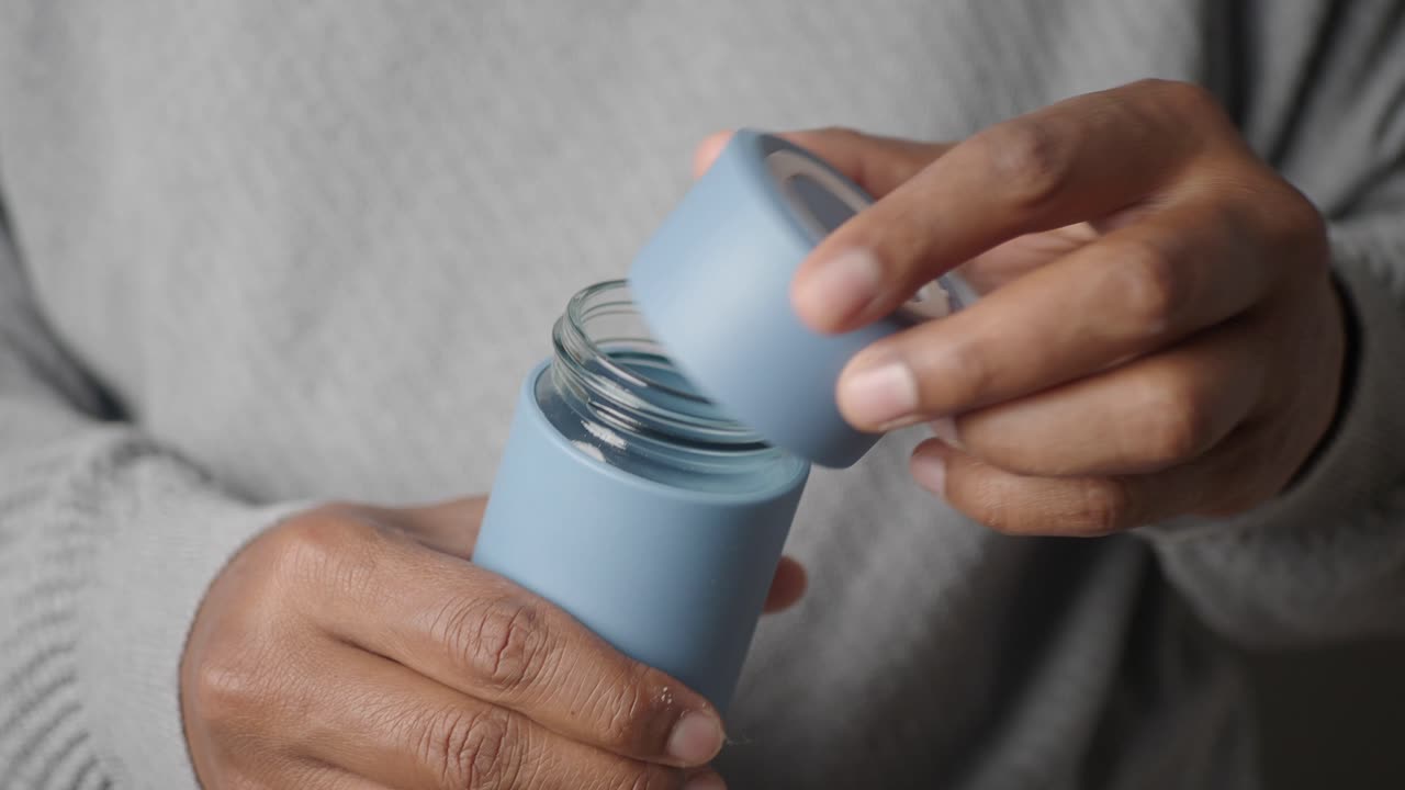 Hands opening reusable glass jar