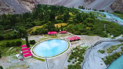 aerial pan shot capturing a beautiful resort with swimming pool in souq valley of skardu, pakistan