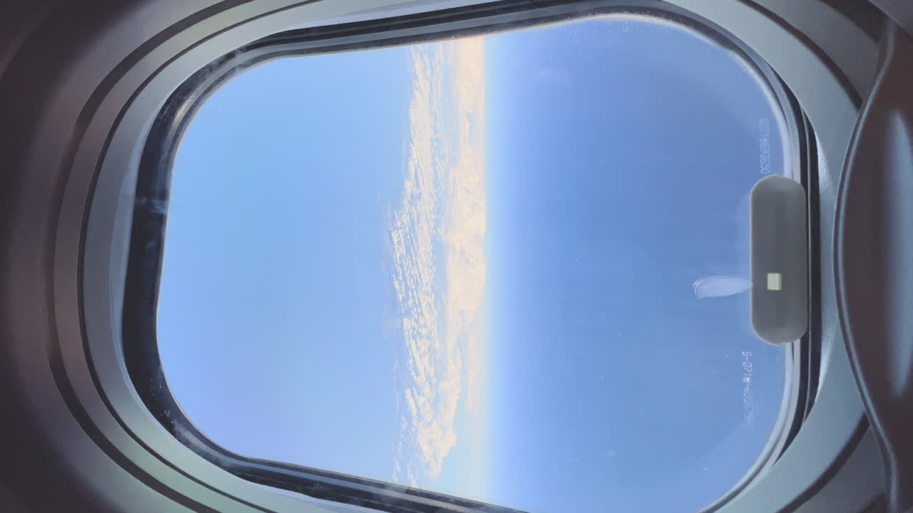 vista vertical del cielo azul y las nubes desde la ventana del avión durante el vuelo