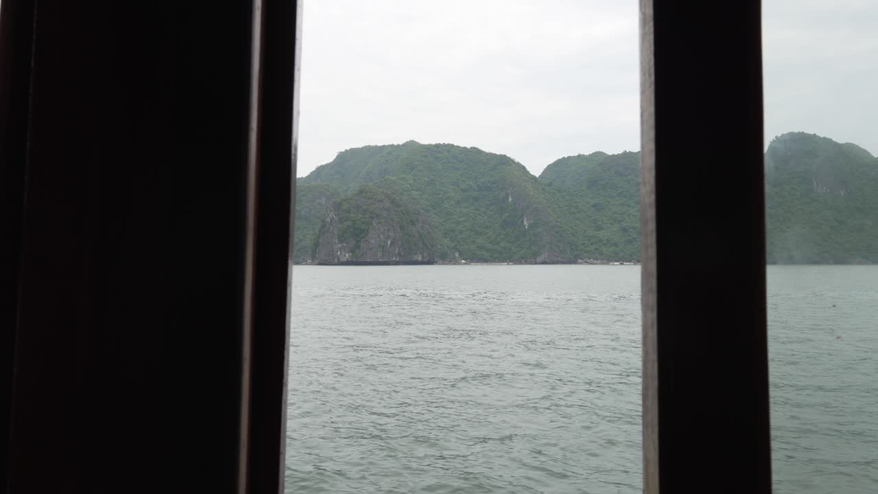 Vista da janela emoldurada de um barco das ilhas cársticas de calcário de Cat Ba, Vietnã
