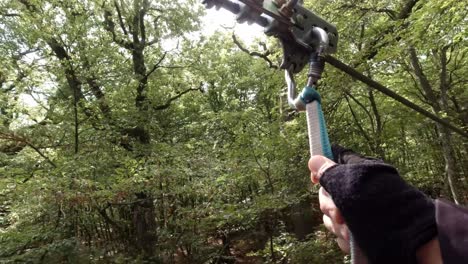 hands attaching carabiner and trolley on zipline rope in the forest