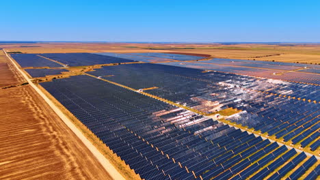 solar panels across landscape. a large solar farm operates under clear blue skies in a rural area, showcasing rows of solar panels absorbing sunlight
