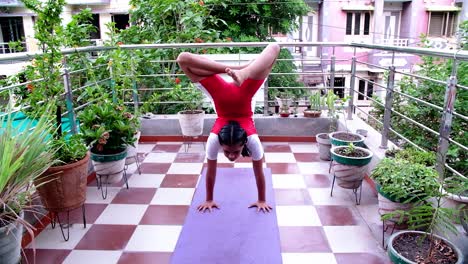 vista frontal de una hermosa joven india en ropa deportiva haciendo yoga, pranayama en su jardín de terraza en posturas de yoga muy difíciles día de yoga interna