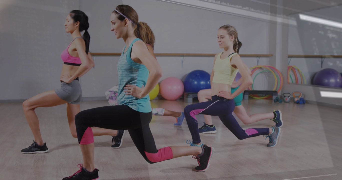 Female fitness group lunging forward in studio wearing athletic wear with code overlay and barre