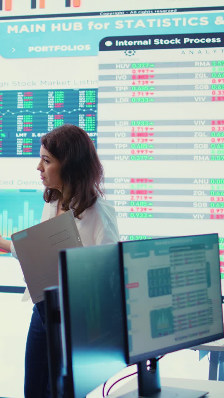 Business Professionals Working in Modern Office with Stock Market Data Screens
