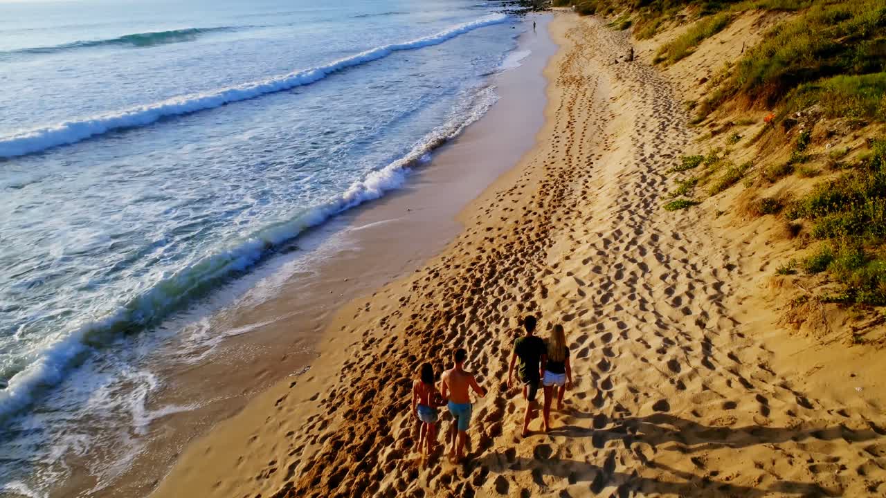 Turistas caminhando na praia 4k