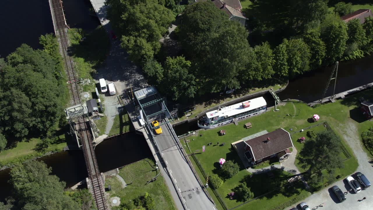 Turist ferry crossing lock in Dalsland canal, Sweden, near a bridge and houses