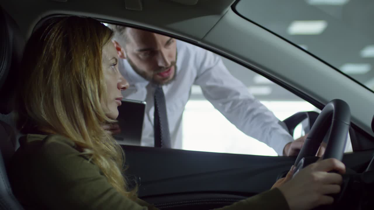vendedor de automóviles hablando con un cliente sentado en el coche