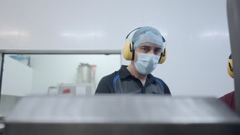 trabajadores de la fábrica inspeccionando la maquinaria