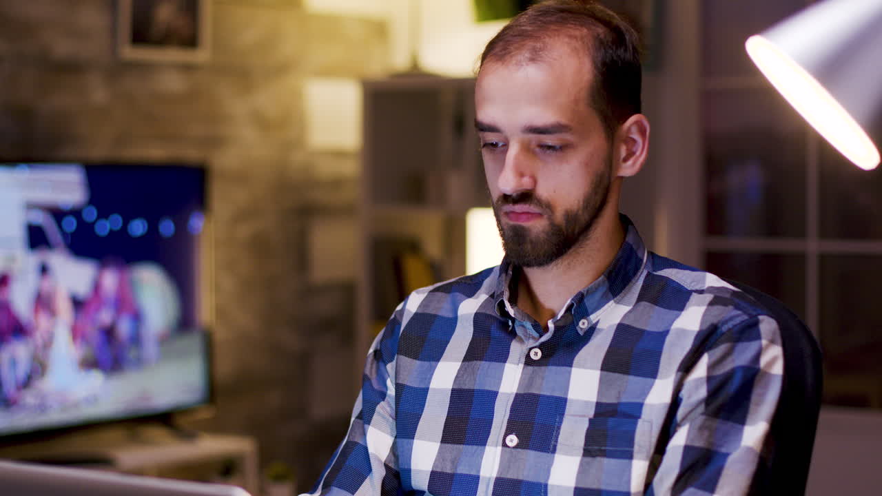 Man Working on Laptop While Drinking at Home