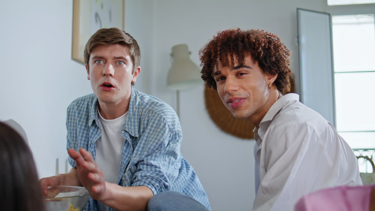 Excited group friends supporting videogame players closeup. Young mates together