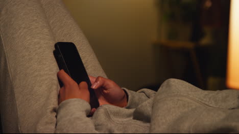 person using a smartphone at home at night