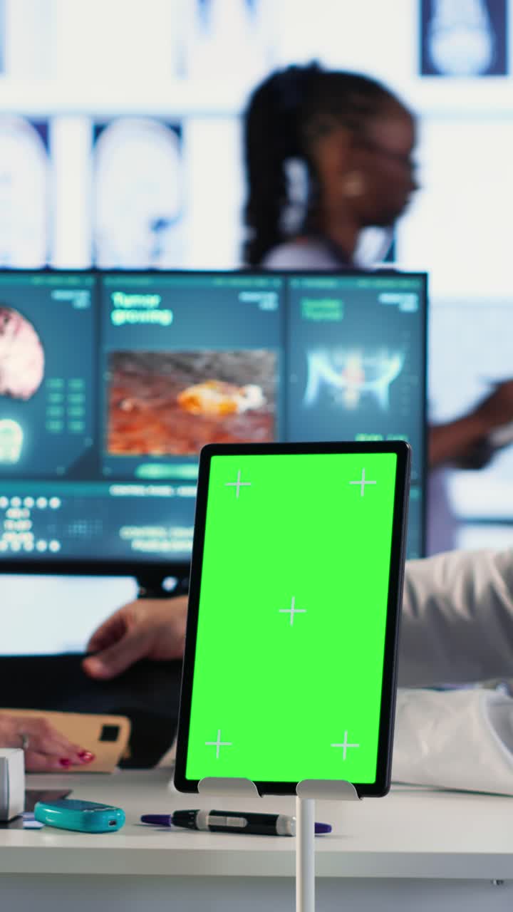 Vertical Video Senior medic talking to his female patient next to mockup green screen