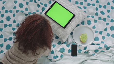 Vista-Superior-De-Una-Mujer-Joven-Usando-Una-Tableta-Viendo-Una-Pantalla-Verde-Relajándose-En-La-Cama-En-Casa-Una-Adolescente-Estudiando-La-Clave-De-Croma