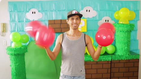 man twisting red balloons at a super mario bros themed party