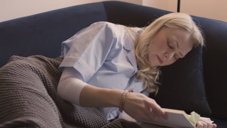 woman reading a book on a couch