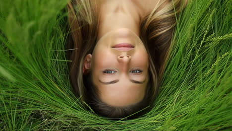 young woman lying in green grass