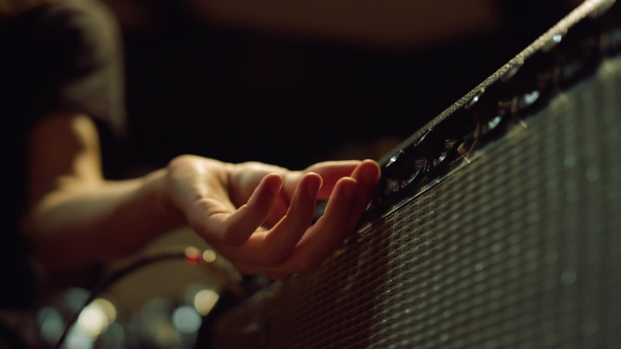 macro hombre mano girando botones en el estudio. ingeniero de sonido ajustando el sonido