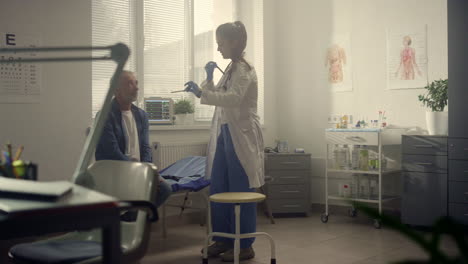 woman therapist examining senior patient throat. old man visit doctor in clinic.