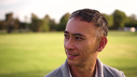 Hopeful-optimistic-man-smiling-in-park,-circling-close-up,-slow-motion