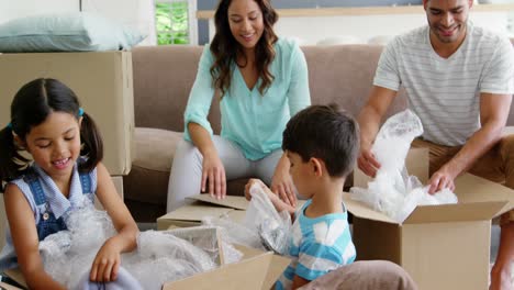 familia feliz desempaquetando cajas de cartón