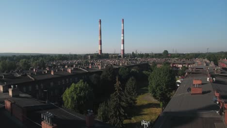 historic red-brick workers' settlement with green parks and cars in the parking lot on a sunny summer day, 4k drone shot