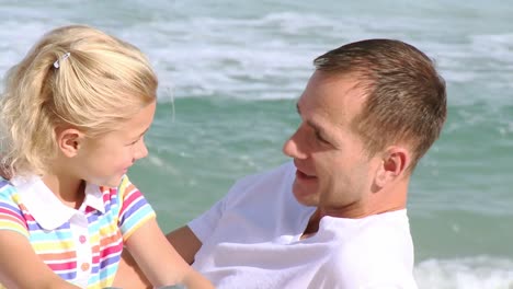 close up of father talking to his daughter on the beach