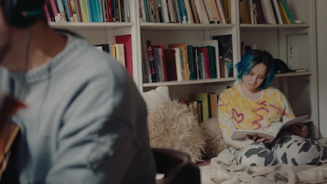 girl reading book and boyfriend recording music at home