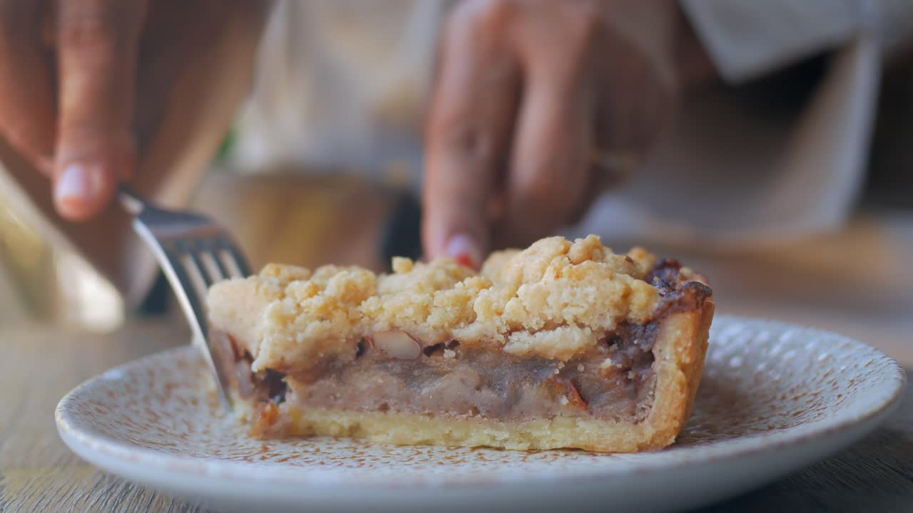 mujer comiendo un pedazo de pastel de migajas de manzana