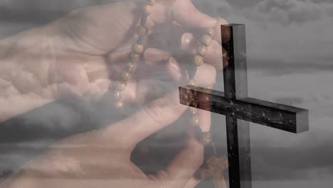 animation of caucasian woman praying with rosary over cross and clouds