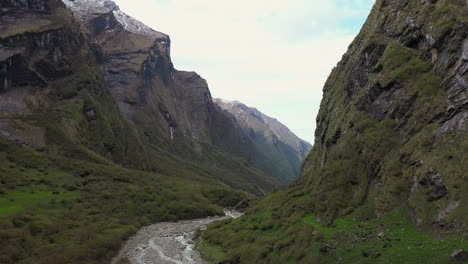 aerial drone footage going through a valley and over a creek in the annapurna mountains