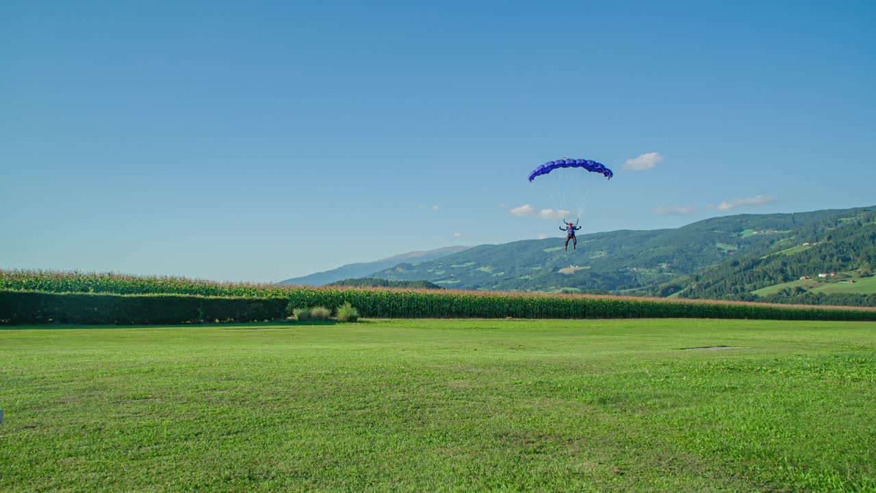 Skydiver on the way to earth lands safely and brings the parachute down