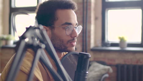 Close-Up-View-Of-Man-With-Eyeglasses-Talking-Into-A-Microphone-Recording-A-Podcast