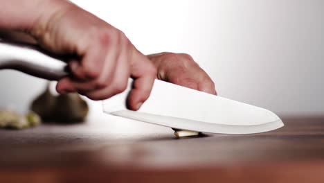 professional chef cutting garlic on wood chopping block