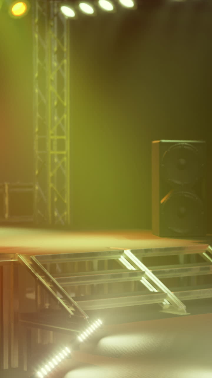 Allestimento del palco per un concerto di musica dal vivo tra luci e ombre serali.