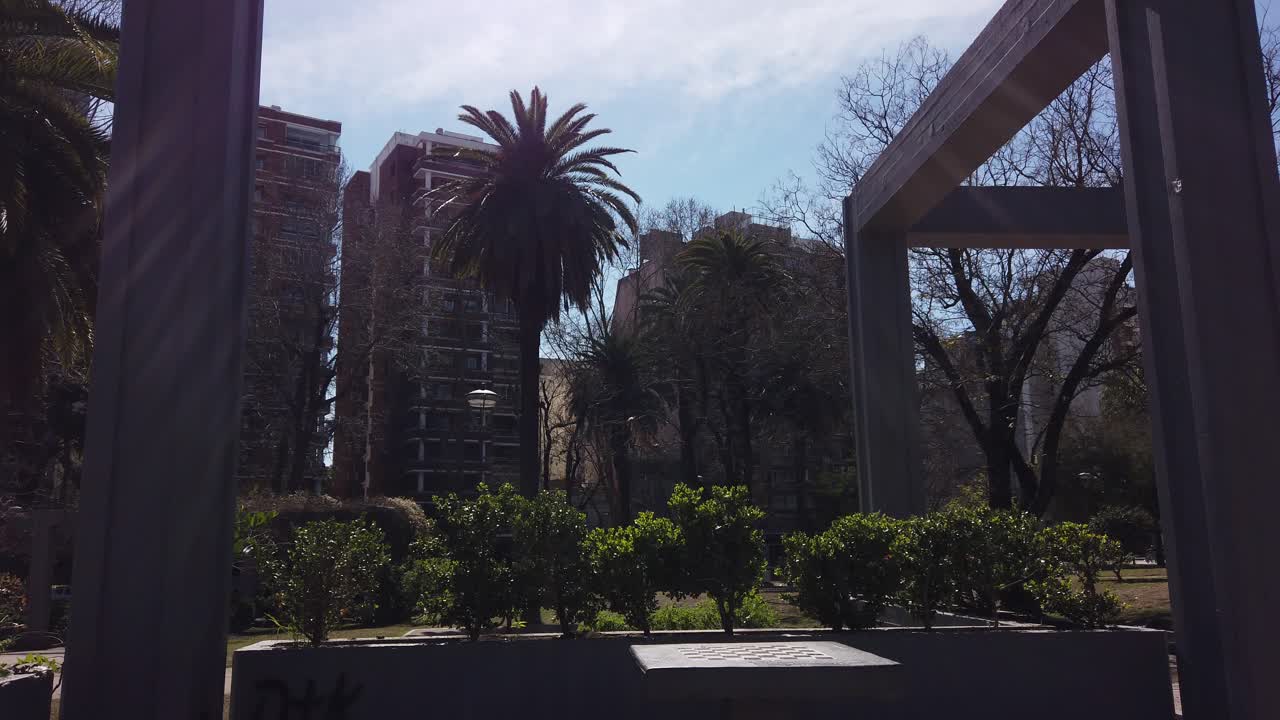Landscape of Angel Gris urban city park of Buenos Aires, Palm trees high buildings background, Flores neighborhood