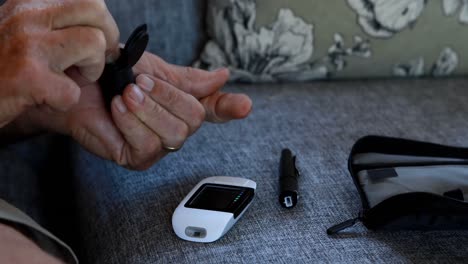 senior man checking blood sugar on glucometer 4k