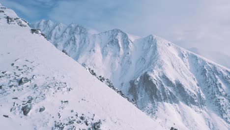 aerial cinematic winter landscape of high peak mountains in tatra national park slovakia revealing valley covered in white fresh snow during a sunny day of winter