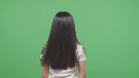 back view of a woman fluttering her long black and blond straight healthy hair in the green screen background studio